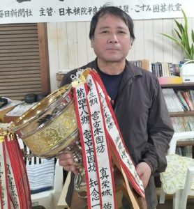 優勝杯を手にする知念一将六段＝22日、こすみ囲碁教室