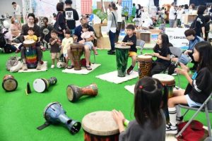 ドラムサークルで太鼓をたたいてまつりを楽しむ子供たち＝２月28日、ＪＴＡドーム宮古島