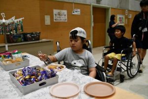 子供たちの長い列ができた「車いすお菓子バイキング」＝２月28日、伊良部公民館