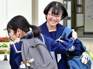 試験が終わって友達と笑顔で抱き合う受験生たち＝５日、宮古高校