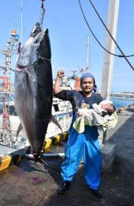 クロマグロを釣り上げた友利さんと長男の海利ちゃん＝19日、荷川取漁港