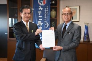 嘉数市長に答申書を手渡す石原会長（左）＝16日、市役所